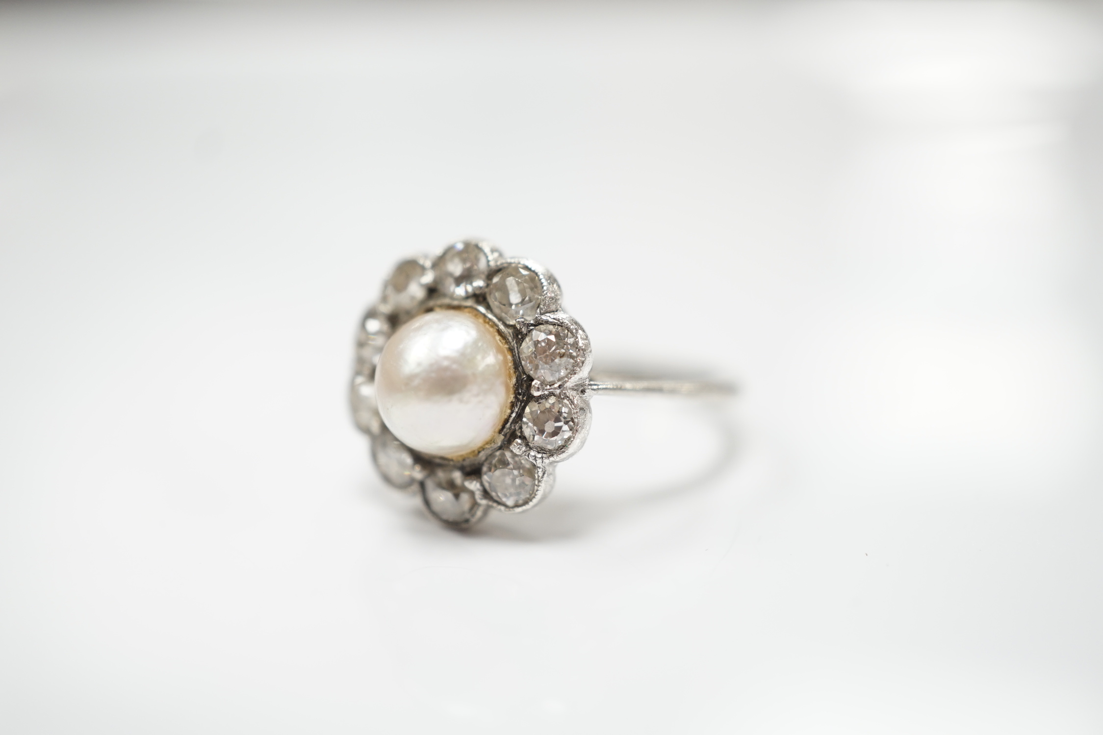A white metal (stamped Pall) cultured pearl and diamond set circular cluster ring, size L, gross weight 3.3 grams.